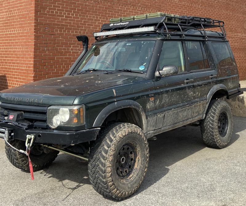 Heavily modified green Land Rover Discovery 2 with aftermarket accessories