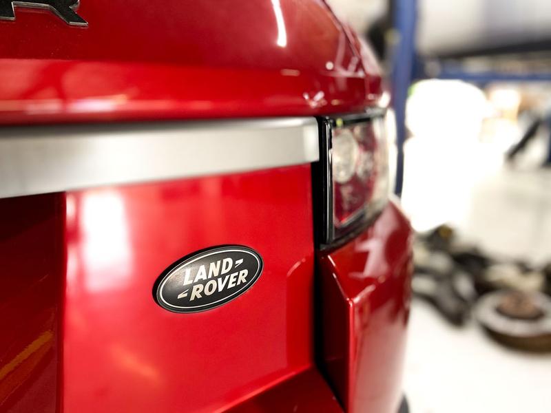 Rear corner close up of a red Land Rover Range Rover showing logo